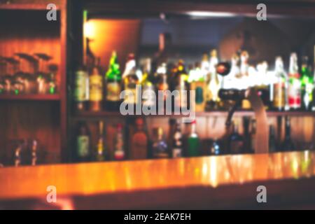 Comptoir de bar classique avec bouteilles sur fond flou, espace de copie ou espace pour le texte. Restaurant ou café à l'arrière-plan coloré et défoqué Banque D'Images