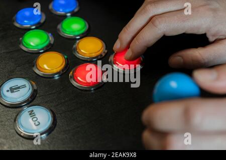 Gros plan de mains jouant arcade vieux jeux vidéo.manette de jeu avec Joystick et de nombreux boutons colorés. Jeux avec l'ancienne technologie rétro concept de farce Banque D'Images