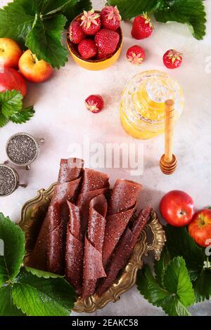 Guimauve aux fraises et graines de chia sur fond blanc. Miel et graines de chia sur fond clair. Bâton de miel. Une alimentation saine. Banque D'Images