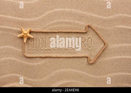 Flèche faite de corde et de coquillages de mer avec le mot Monténégro sur le sable Banque D'Images