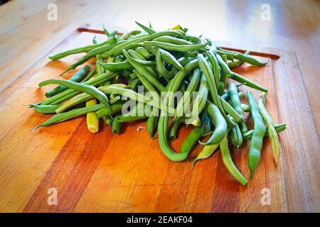 Haricots verts frais au milieu d'une planche à découper Banque D'Images