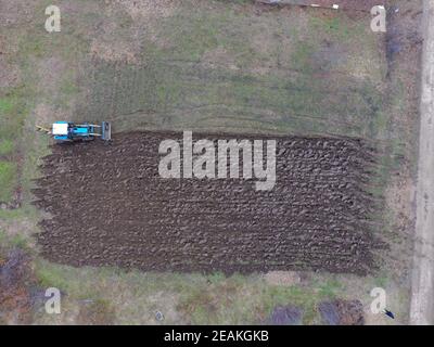 Le tracteur laboure le jardin. Labourer le sol dans le jardin Banque D'Images