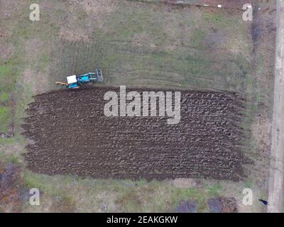 Le tracteur laboure le jardin. Labourer le sol dans le jardin Banque D'Images