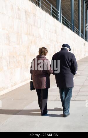 Un couple âgé de plus de 70 ans vu de l'arrière se balader dans une rue vide par une journée ensoleillée. Concept social distance Covid 19 Banque D'Images