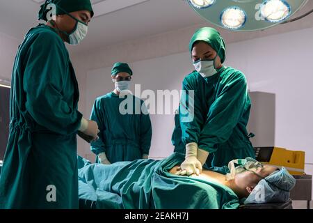 Le chirurgien et l'infirmière font la RCP au patient. Banque D'Images