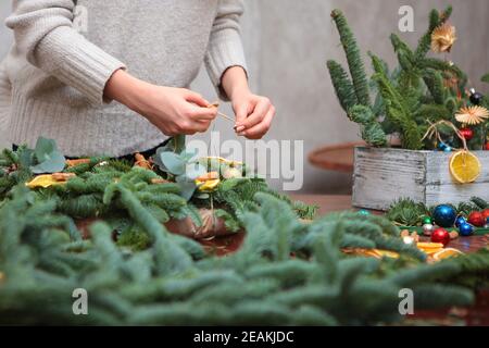 La fille fait ses propres mains accessoire de Noël. Décoration traditionnelle pour le nouvel an ou Noël. Photo sans visages, mains seulement. Banque D'Images