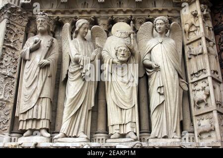 Paris, cathédrale notre-Dame, portail de la Vierge. De gauche à droite : l'empereur Constantine, un ange, Saint Denis tenant sa tête, et un autre ange. Banque D'Images