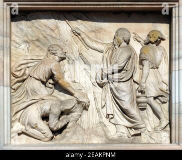 Moïse frappe l'eau de la pierre, en relief sur la façade de la cathédrale de Milan, le Duomo di Santa Maria Nascente, Milan, Lombardie, Italie Banque D'Images