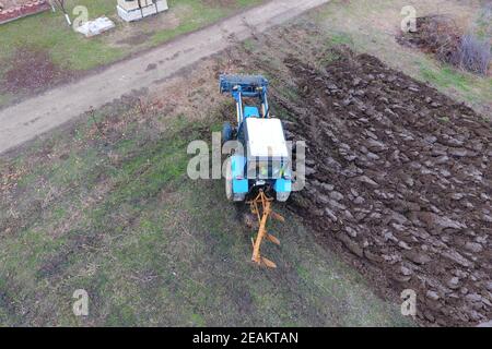 Le tracteur laboure le jardin. Labourer le sol dans le jardin Banque D'Images