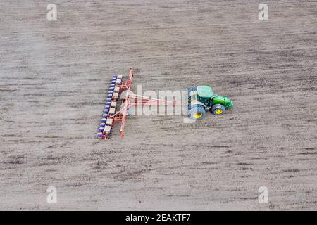 Les semis de maïs. Tracteur avec un semoir sur le terrain. À l'aide d'un semoir pour planter du maïs. Banque D'Images