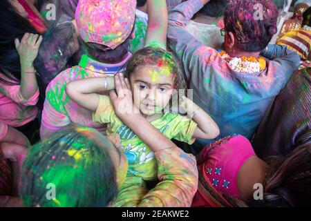 Jodhpur, rajastha, inde - 20 mars 2020: Portrait d'un petit enfant indien mignon célébrant le festival holi, gros plan du visage recouvert de poudre colorée. Banque D'Images