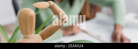 foyer sélectif de figurine humaine en bois près de l'architecte afro-américain sur fond flou, vue rognée, bannière Banque D'Images