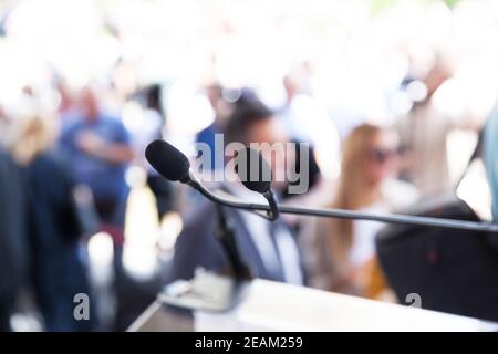 Microphone mis au point dans les médias ou lors d'événements publics, personnes floues en arrière-plan Banque D'Images