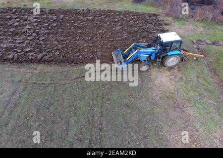 Le tracteur laboure le jardin. Labourer le sol dans le jardin Banque D'Images