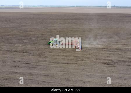 Les semis de maïs. Tracteur avec un semoir sur le terrain. À l'aide d'un semoir pour planter du maïs. Banque D'Images