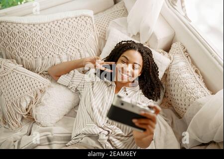 Femme fait selfie dans un lit de camping, vue de dessus, remorque Banque D'Images