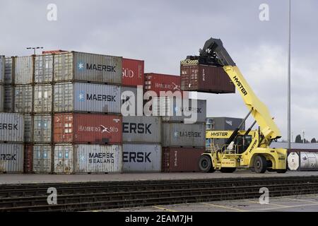 DONCASTER RAILPORT, DONCASTER, ROYAUME-UNI - 29 JANVIER 2021. Une machine de levage lourde empilant un conteneur d'expédition ou de cargaison pour l'exportation et l'importation au Royaume-Uni Banque D'Images