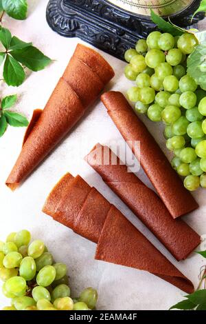 Raisins et Pastilla de raisins sur un fond clair. Produit naturel sans conservateurs. Nourriture pour végétariens. Grappes de raisins sur fond clair. Banque D'Images