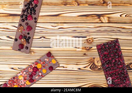 différents types de chocolat avec fruits séchés sur une planche en bois Banque D'Images