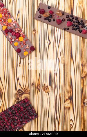 différents types de chocolat avec fruits séchés sur une planche en bois Banque D'Images