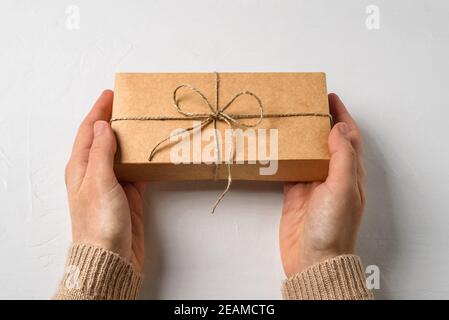 Boîte-cadeau simple en papier avec noeud de ficelle dans les mains de femme Banque D'Images