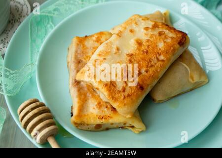Crêpes farcies aux pommes sur une assiette turquoise Banque D'Images