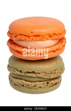 Pâtisseries, desserts et bonbons. Gros plan d'un macaron orange et d'un macaron vert pistache isolé sur fond blanc. Photographie macro. Banque D'Images