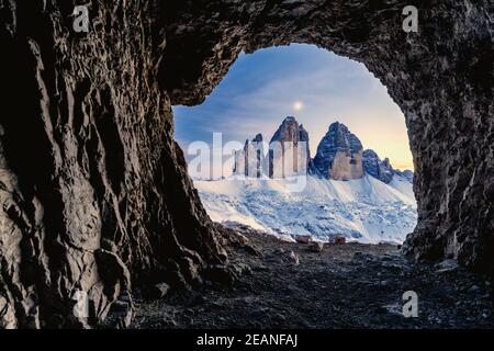 Tre Cime di Lavaredo éclairé par la lune vue de l'ouverture dans les rochers d'une grotte de guerre, Sesto Dolomites, Trentin-Haut-Adige, Italie, Europe Banque D'Images