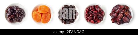 Bol d'abricots séchés, canneberges, dattes, pruneaux et raisins secs isolés sur fond blanc; vue du dessus Banque D'Images