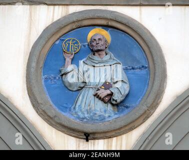 Saint Bernardino de Sienne, tondo en terre cuite émaillée par Andrea della Robbia, situé entre deux arches de l'ancien Ospedale di San Paolo, à Florence, en Italie Banque D'Images