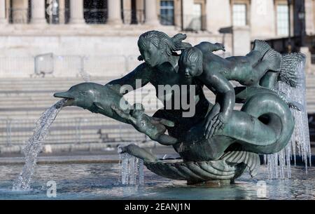 Londres, Royaume-Uni. 10 février 2021. Photo prise le 10 février 2021 montre des glaçons autour de sculptures sur la fontaine de Trafalgar Square à Londres, en Grande-Bretagne. Depuis plusieurs jours, la tempête Darcy a provoqué des neows à Londres. Credit: Han Yan/Xinhua/Alay Live News Banque D'Images