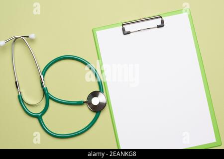 stéthoscope médical et porte-feuille sur fond vert Banque D'Images