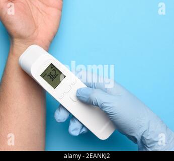 le processus de mesure de la température du corps sur le poignet avec un thermomètre sans contact Banque D'Images