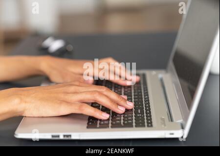 Gros plan de femmes élégantes mains taper du texte sur le clavier de l'ordinateur portable, femme d'affaires répondant à l'e-mail du client, acheter des articles en ligne Banque D'Images
