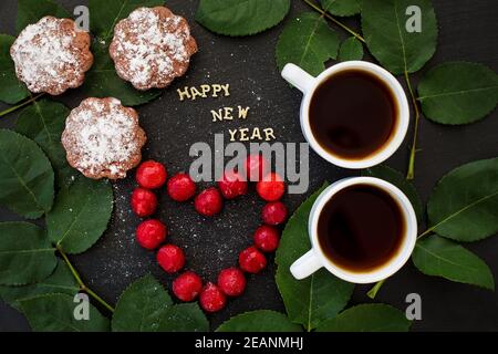 inscription du nouvel an sur un tableau noir avec cupcake et coeur dans la forme cerises Banque D'Images