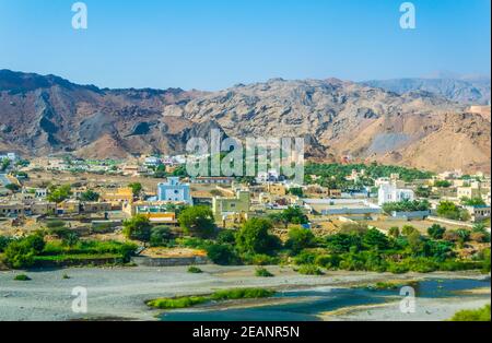 Vue sur une oasis et un village sous la chaîne de montagnes de Hajar en Oman. Banque D'Images