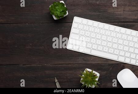 clavier et souris sans fil blancs sur une table en bois marron Banque D'Images