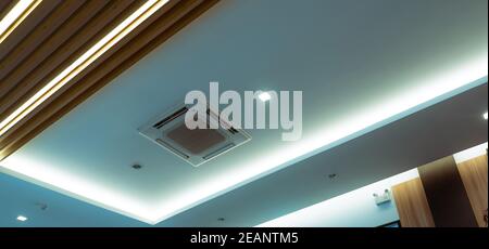 Mise au point sélective sur le climatiseur à cassette monté sur le mur du plafond. Conduit d'air au plafond de l'hôtel. Unité de cap d'air sur paroi en gypse. Système de refroidissement dans le bâtiment. Système de ventilation et de débit d'air. Banque D'Images