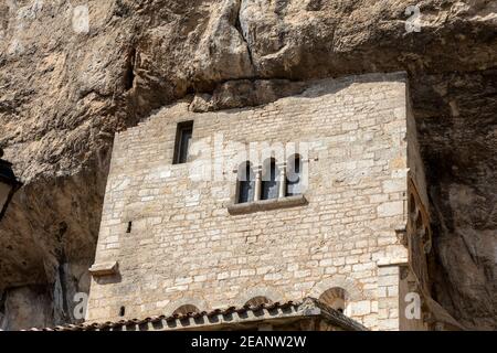 Les murs en pierre de Basilique historique de St-Sauveur se fondent dans la falaise à Rocamadour, France Banque D'Images