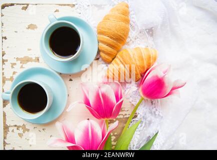 Bonne tasse de café, des croissants et des tulipes roses sur le vieux tableau blanc Banque D'Images