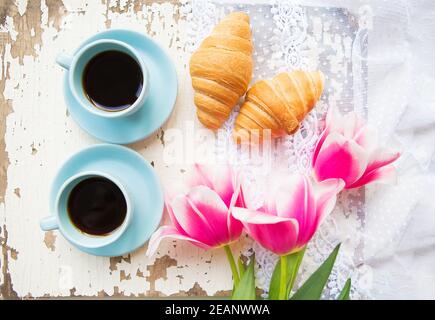 Bonne tasse de café, des croissants et des tulipes roses sur le vieux tableau blanc Banque D'Images