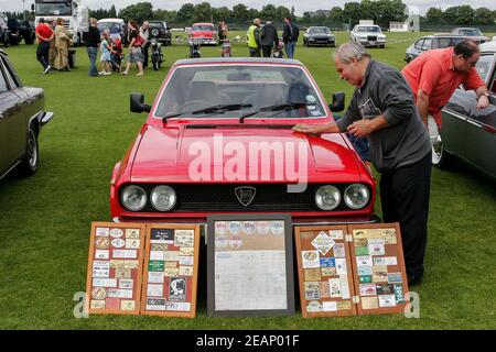 Fier propriétaire de Red Lancia pour polir le capot lors d'un salon automobile classique, au Royaume-Uni Banque D'Images