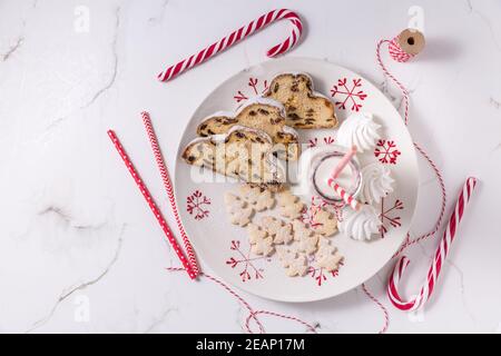 Bouteille de lait avec un stollen de Noël traditionnel, petits biscuits et canne à sucre Banque D'Images