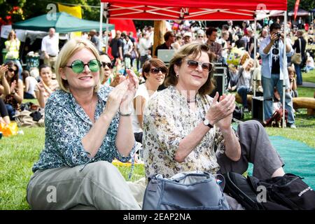 Deux dames assises sur l'herbe, regardant un spectacle et des applaudissements au festival souterrain de Crystal Palace, dans le sud de Londres Banque D'Images