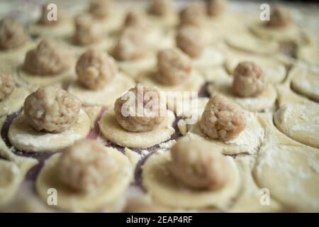 Garniture de viande sur les cercles de pâte en cours de cuisson les boulettes sont rapprochées Banque D'Images