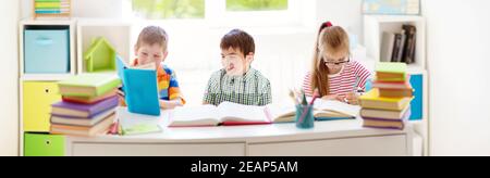 Les enfants avec des sacs à dos assis sur l'escalier près de l'école Banque D'Images