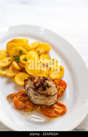 filet de porc au bacon sur poivre avec pommes de terre et tomates Banque D'Images