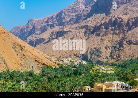 Vue aérienne d'un village entouré d'une forêt de palmiers dans le Wadi Tiwi en Oman. Banque D'Images