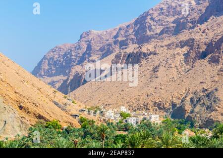 Vue aérienne d'un village entouré d'une forêt de palmiers dans le Wadi Tiwi en Oman. Banque D'Images