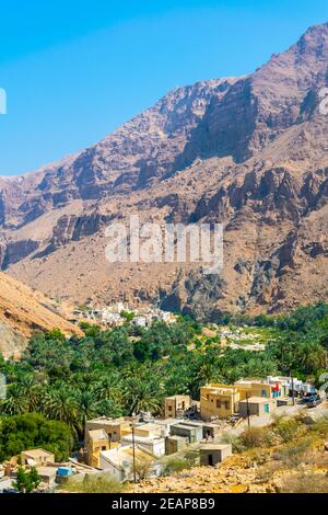 Vue aérienne d'un village entouré d'une forêt de palmiers dans le Wadi Tiwi en Oman. Banque D'Images